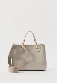 Beige Emporio Armani-veske med to håndtak, gulldetaljer og en avtagbar skulderrem med merke som ligger sammenrullet ved siden av.