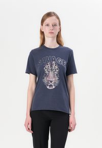 T-shirt in cotone blu navy con una grafica della faccia di una tigre e la parola "SAVAGE" in lettere maiuscole sopra di essa. Maniche corte e scollo rotondo.