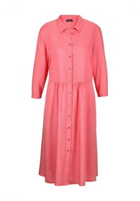Korallenfarbenes Hemdkleid mit Kragen und Dreiviertelärmeln, das eine geraffte Taille und eine glatte Stofftextur aufweist.