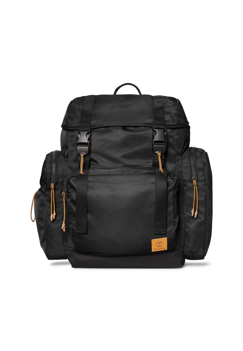 Zaino in tessuto nero con due tasche laterali, pattina superiore, spallacci regolabili e dettagli in pelle marrone. Presenta cerniere e chiusure a coulisse.