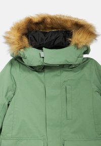 Πράσινο εξωτερικό μπουφάν με κουκούλα επενδεδυμένη με ψεύτικη γούνα, με φερμουάρ μπροστά και πλάγιες τσέπες. Κατασκευασμένο από υφασμένο ύφασμα με λεία εσωτερική επένδυση.