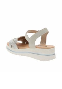 Sandal grigio chiaro con una striscia glitterata e design incrociato, dotato di una soletta imbottita e una spessa suola in piattaforma bianca.
