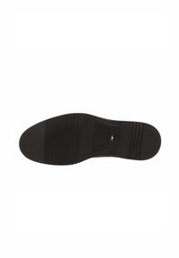 Black rubber shoe sole with horizontal and vertical grooves, featuring a small logo and a green, white, and red accent near the heel.