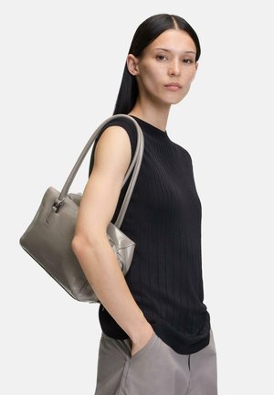 Top senza maniche a coste nere abbinato a una borsa in pelle grigia con una finitura liscia e manici corti; il modello si trova su uno sfondo bianco.