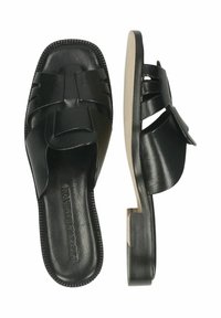 Zwarte leren slidesandalen met een geweven bandontwerp, een platte zool en een kleine blokhak voor extra ondersteuning. Gladde textuur overal.