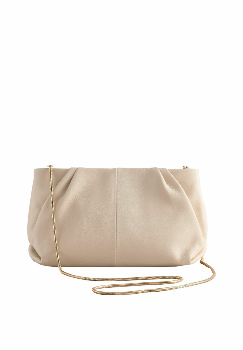 Pochette en cuir souple beige avec de délicats plis et une fine lanière chaîne dorée posée devant sur un fond blanc.