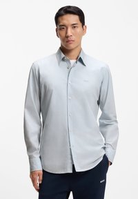 Ανοιχτό μπλε πουκάμισο με κουμπιά, κατασκευασμένο από λεία ύφανση, με κλασικό γιακά και μακριά μανίκια. Κέντημα λογότυπου στο στήθος.