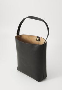 Black leather tote bag with a smooth texture, wide open top, and a single handle. Interior is tan with a gold snap closure detail.
