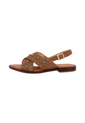 Sandalo in suede marrone con fasce incrociate, dettagli blu e borchie dorate. Presenta una chiusura a fibbia e una suola piatta per il comfort.