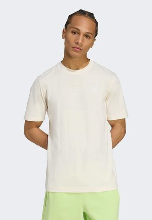 Light beige crew-neck t-shirt made of soft cotton, featuring short sleeves and a small white logo on the chest.