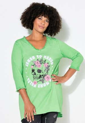 Green cotton tunic shirt with a distressed V-neck, 3/4 sleeves, featuring a skull and rose graphic, and a relaxed fit with frayed hems.