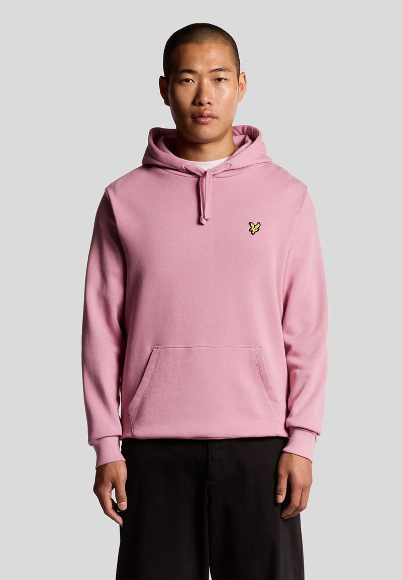Felpa rosa con cappuccio e cordino, tasca frontale e piccolo logo giallo sul petto. Tessuto morbido e texture con maniche lunghe.