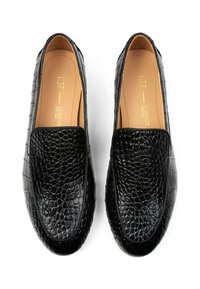 Zwarte loafers van geëmbossed leer, met een gladde voering, ronde neus en een laag profiel ontwerp. Geen zichtbare hardware.