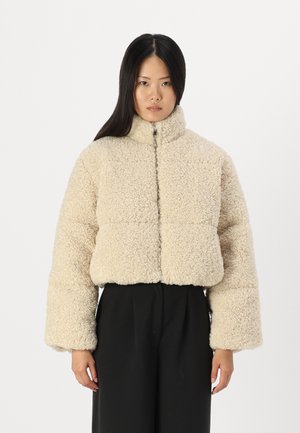 Cream-colored, fluffy cropped jacket with a high collar and zip closure. Features wide, oversized sleeves and a textured surface.