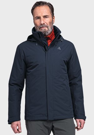 Giacca impermeabile blu navy con cappuccio, dotata di una fodera interna rossa, tasche frontali e un piccolo logo sul petto. Texture liscia.