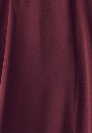 Burgundijas krāsu audums ar gludu, matētu tekstūru. Iztur karājošus elementus, kas rada maigus krokus, uzlabojot kopējo izskatu.