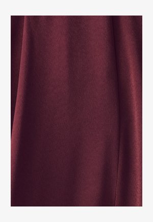 Burgundi värviga kangas, mis on sile ja mati tekstuuriga. Omab õrnu longuseid, mis loovad pehmeid voldikesi, rõhutades kogu välimust.