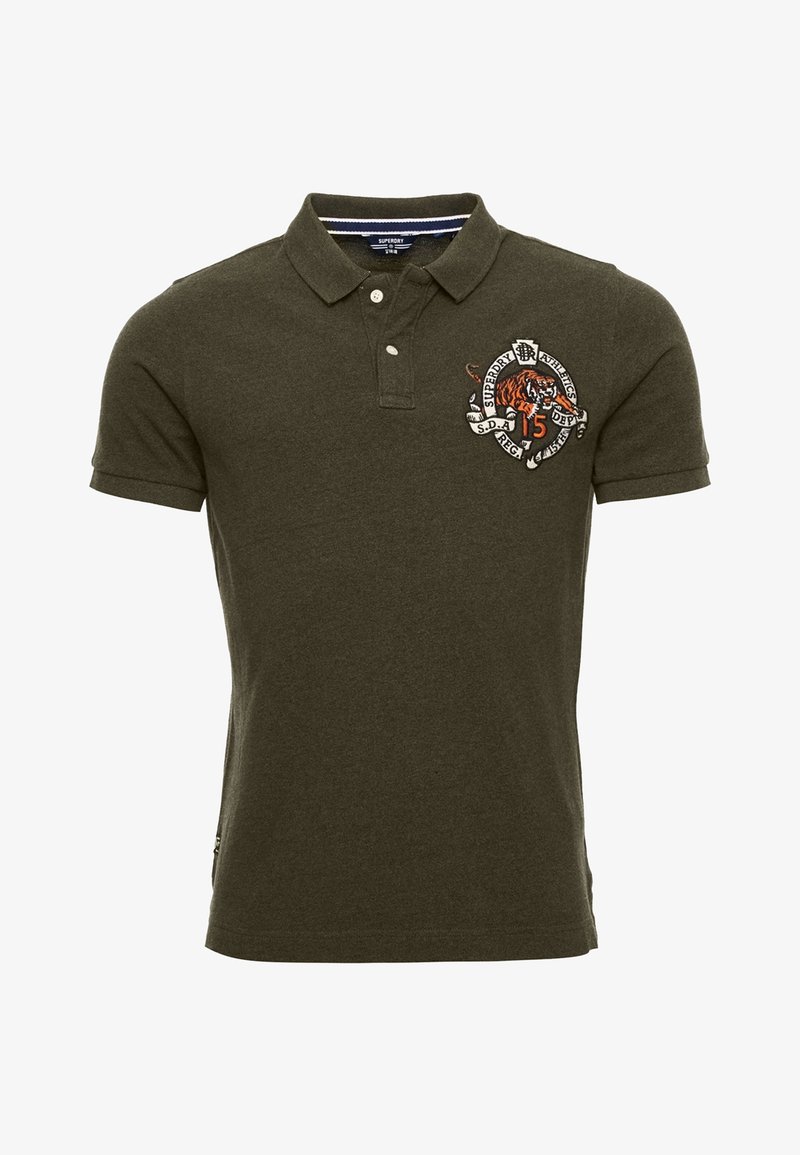 Polo à manches courtes vert foncé avec patte de boutonnage à deux boutons et patch brodé représentant un tigre et du texte sur la poitrine gauche.