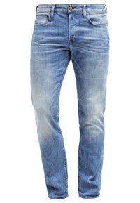Ljust blå smalt skurna denimjeans med lätt blekning och whisker-effekter, med fram- och bakfickor, bälteshällor och knappstängning.
