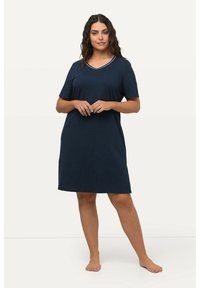 Námornícky modrá nočná košeľa s krátkymi rukávmi a výstrihom do V, s bielym bodkovaným vzorom a mierne rozšíreným strihom pre voľné nosenie.