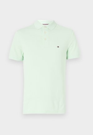 Polo de algodón verde claro con una tapeta de dos botones y un pequeño logo bordado en el lado izquierdo del pecho. Mangas cortas y corte moderno.