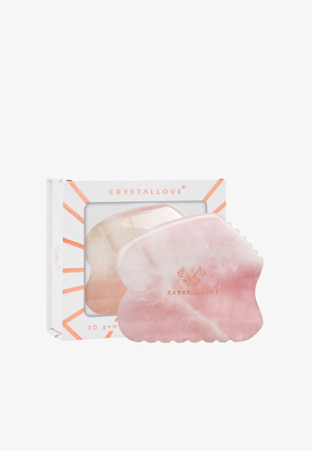 Gioiello 3D realizzato in cristallo rosa chiaro lucido con bordi arrotondati, caratterizzato da un logo dorato sulla superficie, presentato in una scatola con un design geometrico.