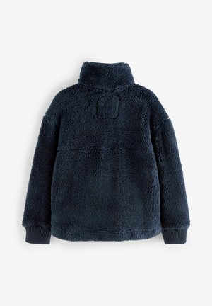 Pull en polaire bleu marine avec col montant, affichant une surface texturée et douce ainsi que des poignets côtelés. Aucune fermeture ni ornement visible.