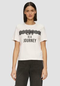 Witte katoenen T-shirt met korte mouwen en een ronde halslijn, voorzien van zwarte kantdecoratie en de tekst "LIFE IS A JOURNEY" in vette letters.
