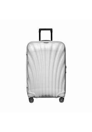 Valise rigide argentée avec des rainures texturées, poignée noire rétractable et quatre roues noires pour la mobilité.