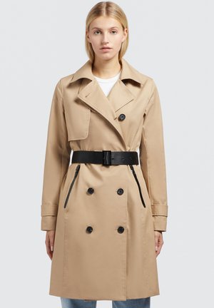 Beige trenčkot s dvojicí knoflíků, černými knoflíky, velkým límcem, opaskem v pase a bočními kapsami, vyrobený z hladké látky.