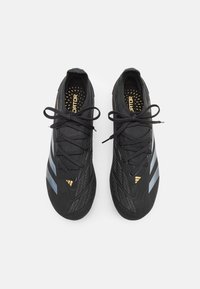 Zwarte sportschoenen met een gestructureerd oppervlak, voorzien van drie lichtblauwe strepen, zwarte veters en gouden branding op de binnenzool.