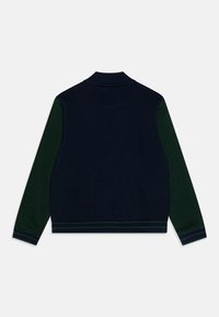 Maglione blu navy con maniche verdi, colletto e polsini a coste, design a tinta unita, texture morbida, con dettagli a righe all'orlo.