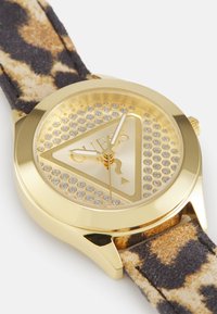 Reloj dorado con una esfera triangular, acentos de strass y una correa de tela con estampado de leopardo. Manecillas de hora y minuto simples, sin números.
