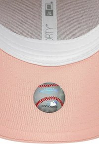Cappello rosa con tessuto testurizzato. Visiera bianca, con un adesivo argento che presenta un design di baseball e il testo "Major League Baseball."
