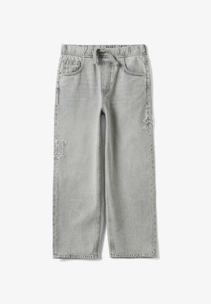 Jean en denim gris clair avec taille élastique et cordon, avec une texture délavée et des patchs usés cousus sur les jambes.