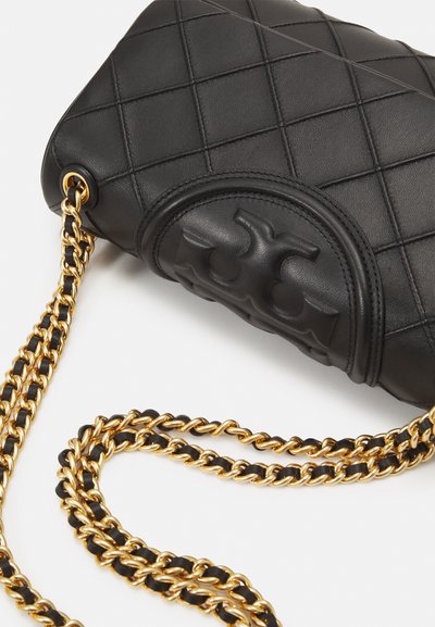 Black leather quilted handbag with a gold chain strap and embossed logo detail. Features a smooth texture and a rectangular shape.