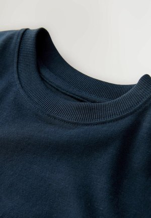 Tummansininen huppari, jossa on teksturoitu ribbikuvioinen pyöreä kaula-aukko ja pehmeä, sileä kangas. Ominaisuuksiin kuuluu klassinen, rento istuvuus.