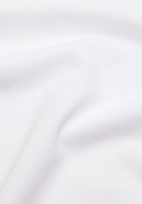 Biała tkanina o teksturowanej, lekko wypukłej powierzchni; układająca się w miękkie fałdy i jednolity, czysty kolor bez wzorów i akcentów.