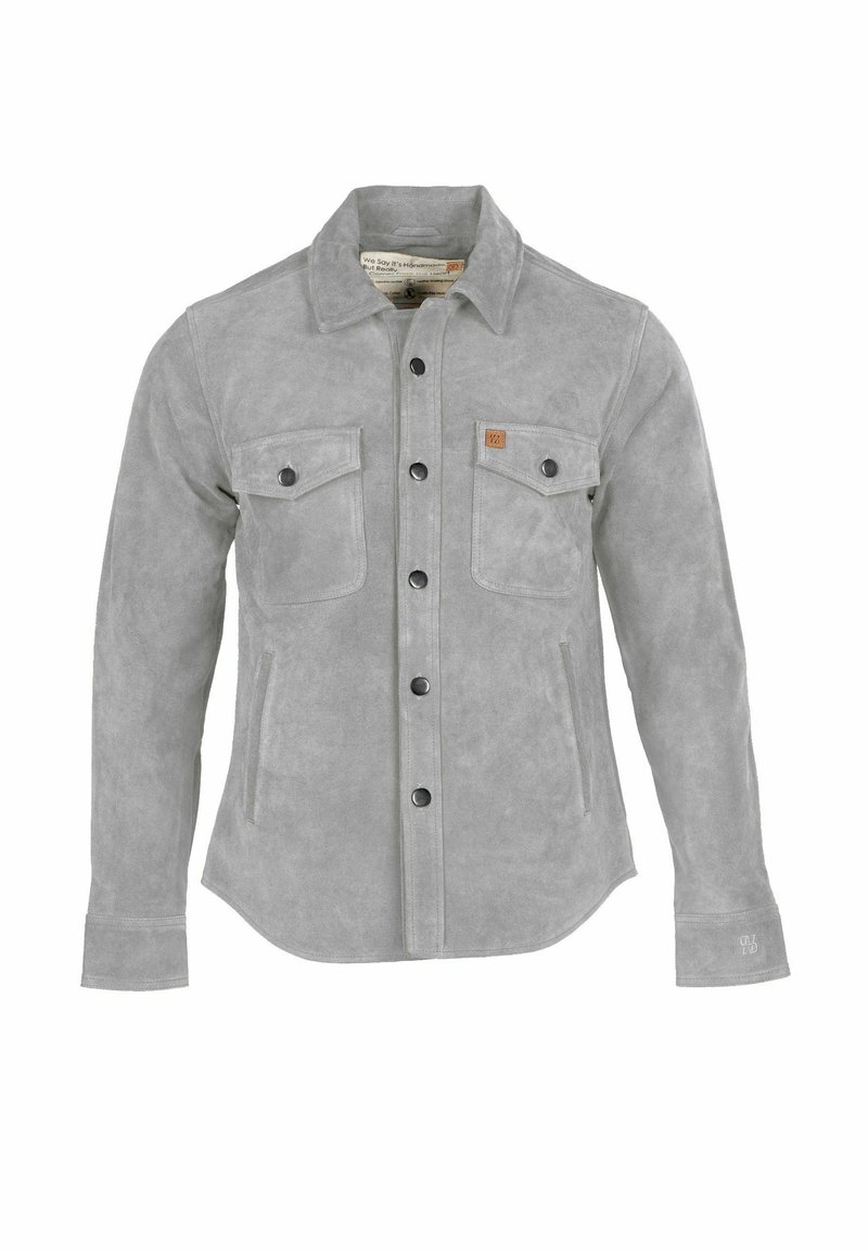 Szürke szarvasbőr dzseki gombos elülső résszel, két mellzsebbel és hajtókás gallérral. Fekete gombokkal és kis márkázott bőrpáccal rendelkezik.