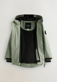 Lichtgroene jas met capuchon, voorzien van een zwarte fleece voering, met een rits aan de voorkant en logodetails. Glad uiterlijk met contrasterende texturen.