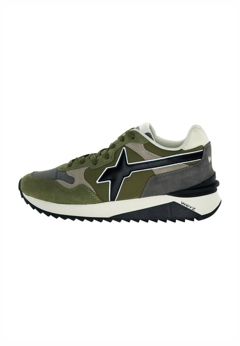Sneaker verde e grigia con una parte superiore in tessuto testurizzato, logo a stella nera e accenti bianchi. Presenta una suola ammortizzata con un battistrada a zigzag.
