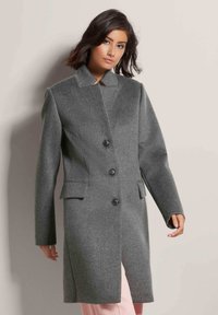 Grijze wollen jas met een notch-kraag, zes zwarte knopen, twee zijzakken en een rechte pasvorm. Soepele textuur en op maat gemaakte fit.
