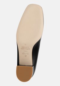 Semelle en cuir noir avec une semelle intérieure beige. Présente le marquage "HENRY STEVENS BERLIN" et la taille "37." Texture lisse avec un talon arrondi.