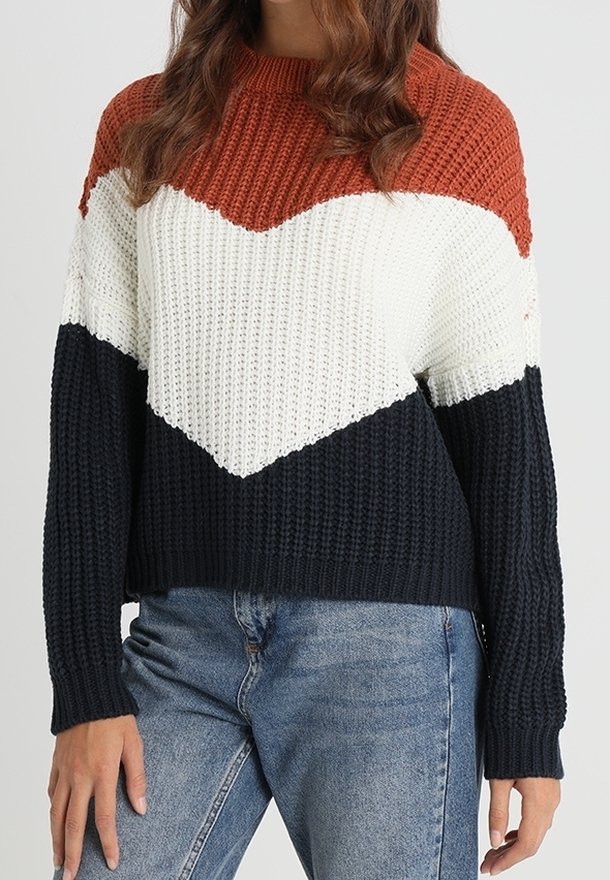 Sweter dziany w kolorach rdzawego, białego i granatowego z wzorem w jodełkę. Prążkowana faktura, długie rękawy i luźny fason. Swobodny styl z widocznymi szwami.