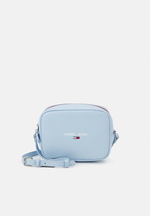 Light blue crossbody bag made of smooth material, featuring a rectangular shape, silver hardware, and "TOMMY JEANS" logo with color accents.
