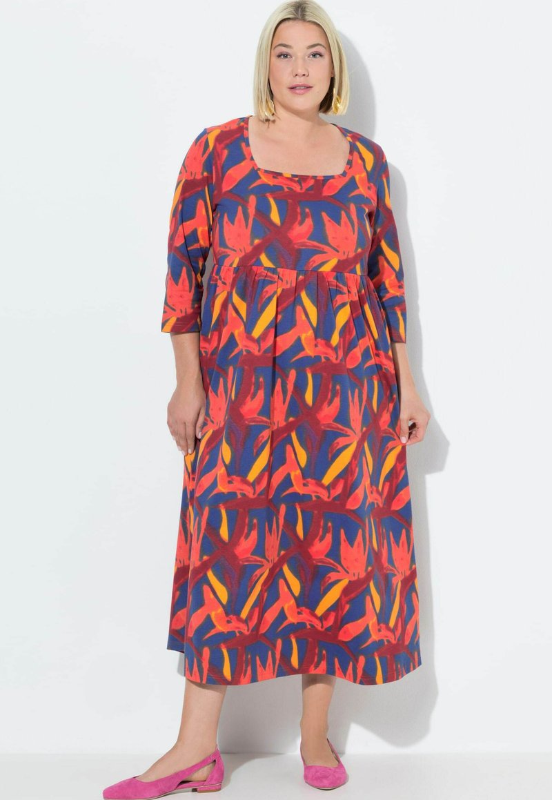 Värikäs kukkakuosis maxi-mekko, jossa on kolme neljännesvartta, neliönmuotoinen pääntie, monivärisiä punaisia, keltaisia ja sinisiä kuvioita sekä pehmeä kangas.