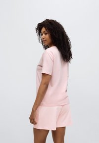 Σετ από ανοιχτό ροζ βαμβακερό T-shirt και σορτς, με κοντά μανίκια, άνετη εφαρμογή, απαλής υφής, με μίνιμαλ σχεδιασμό, κατάλληλο για καθημερινή χρήση.