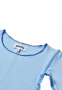 Top a coste blu chiaro con rifiniture blu, caratterizzato da un collo rotondo. L'etichetta mostra il marchio "Molo" e informazioni sulla taglia. Tessuto morbido.