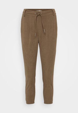 Pantalons en velours côtelé marron avec une taille à cordon de serrage, dotés de plis à l'avant et de jambes effilées. Le tissu a une apparence texturée et côtelée.