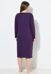 Lila långärmad nattskjorta, tillverkad av mjukt tyg, med rund halsringning och ankellång design, med en slät textur och enkel silhuett.